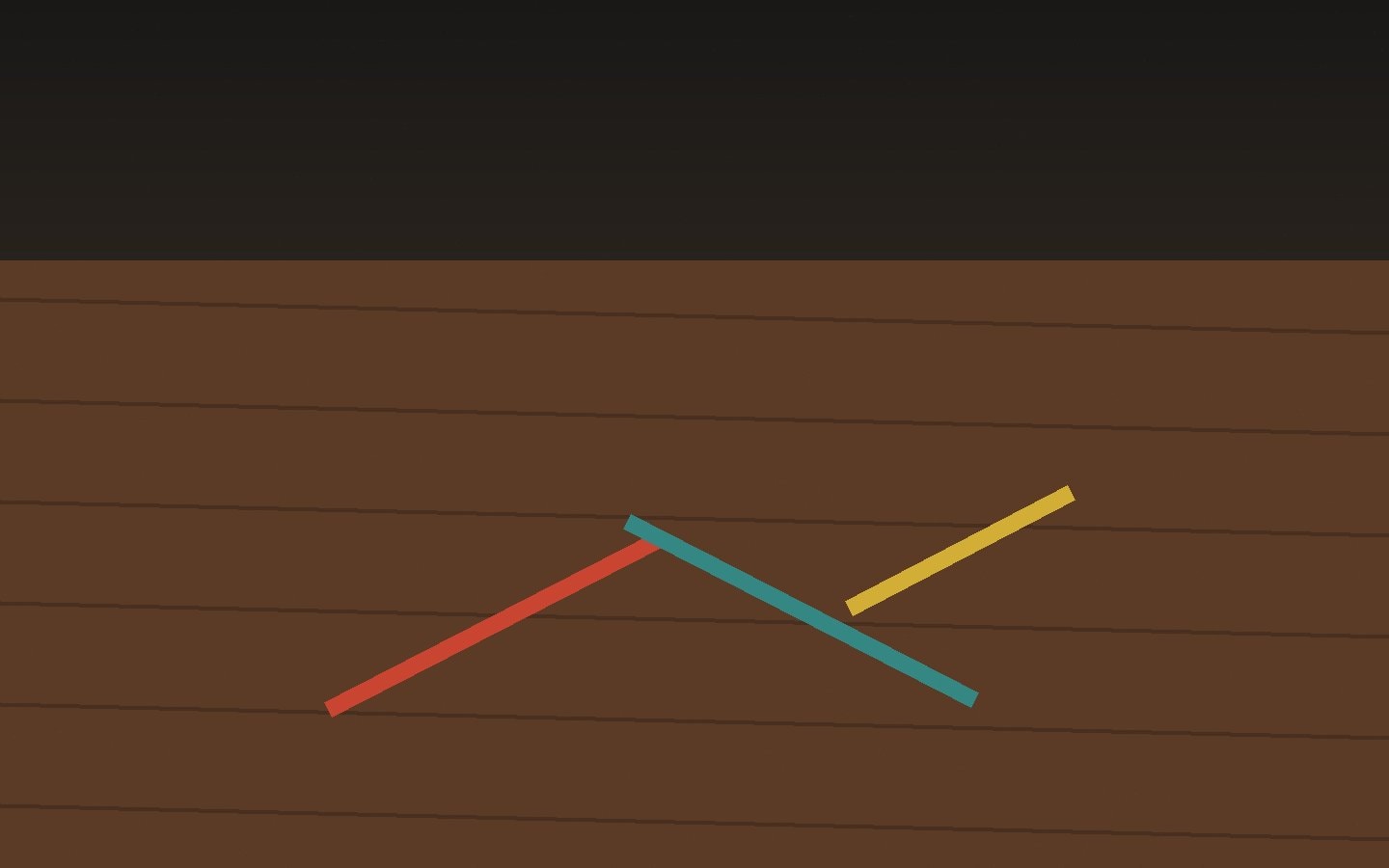 A wooden stage floor crossed by coloured tape marks